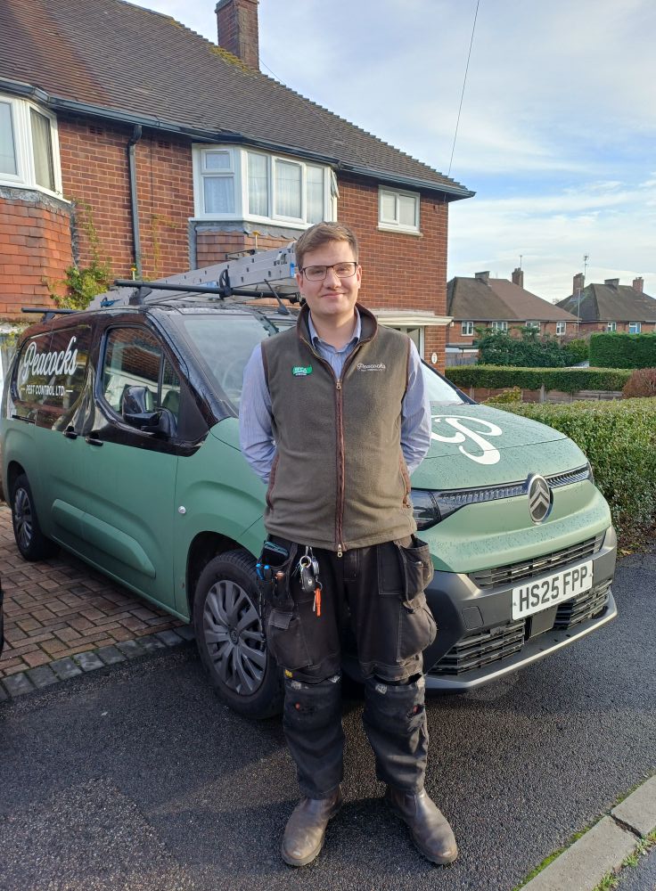 Pest controller standing in front of a branded van
